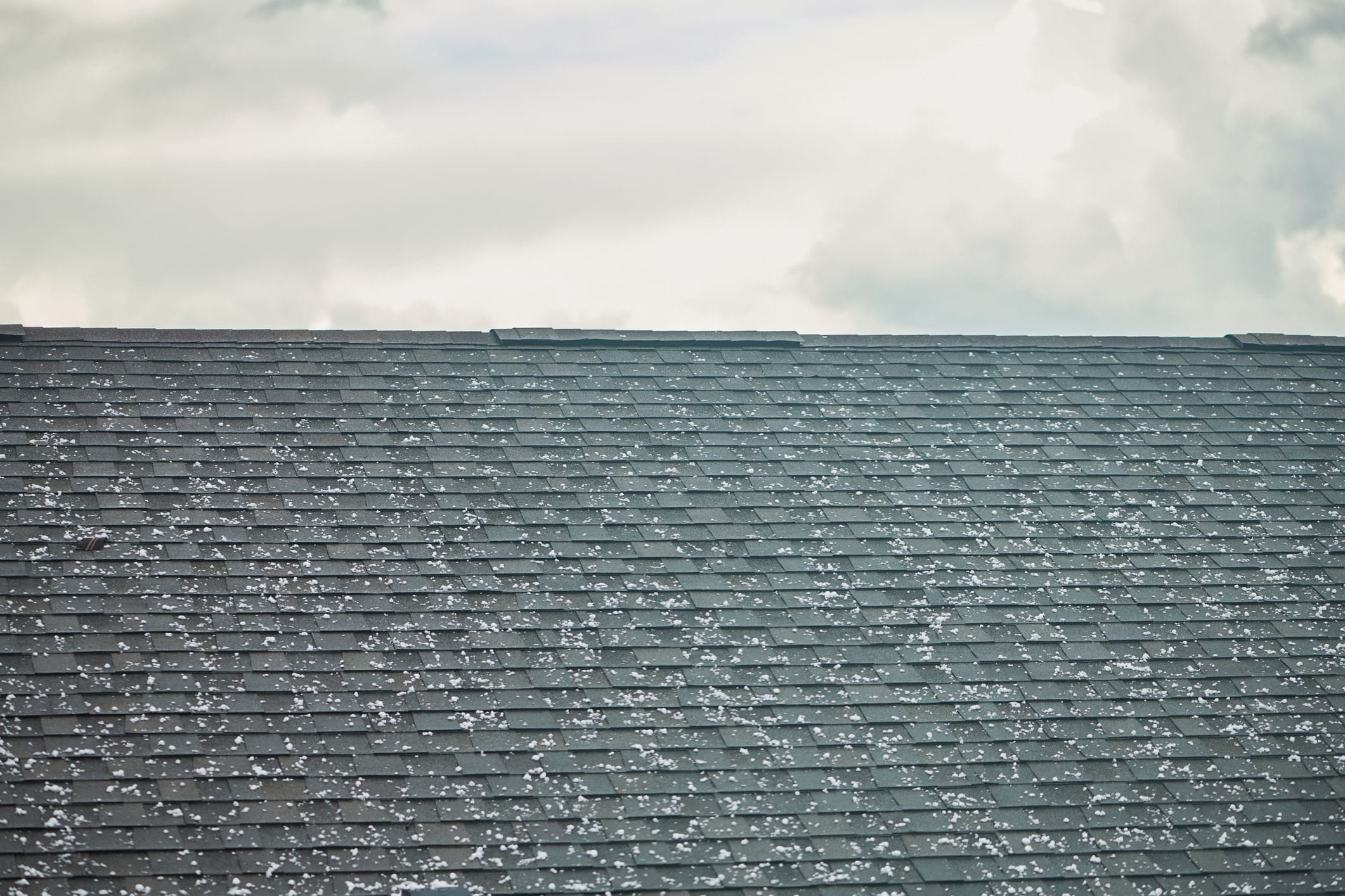 Roof shingles with large hailstones after hail storm